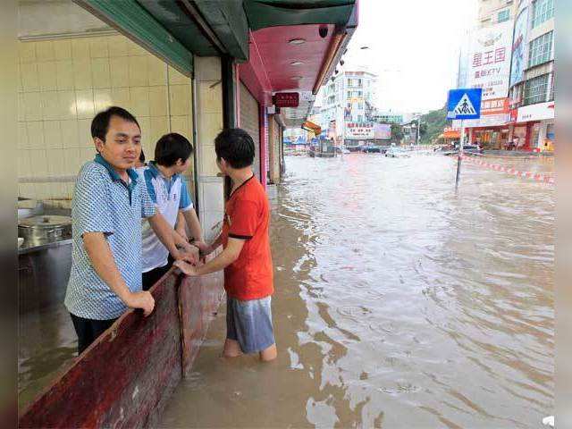 People standing at a makeshift flood barrier