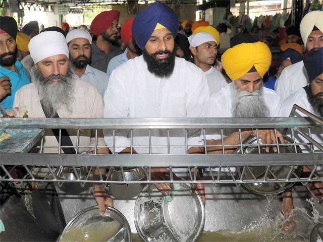 Bikram Singh Majithia washes dishes at the Golden Temple