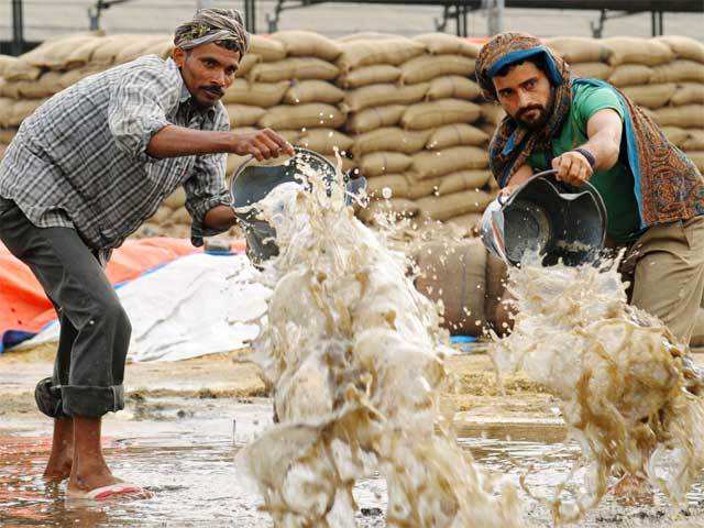 Labourers bail accumulated rainwater in Amritsar