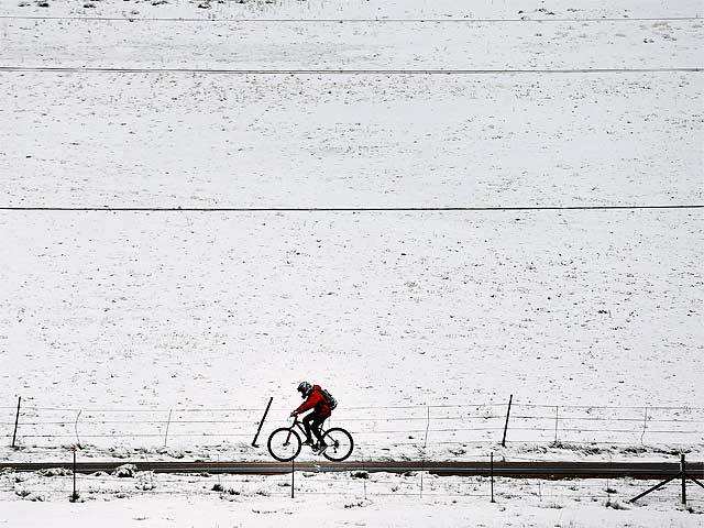 Biker passes fresh snow