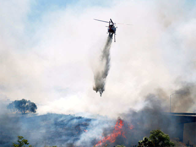 A helicopter attacks a wild fire burning in San Diego