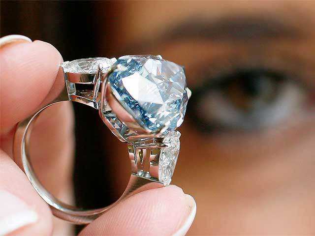 Employee poses with 'The Blue' diamond