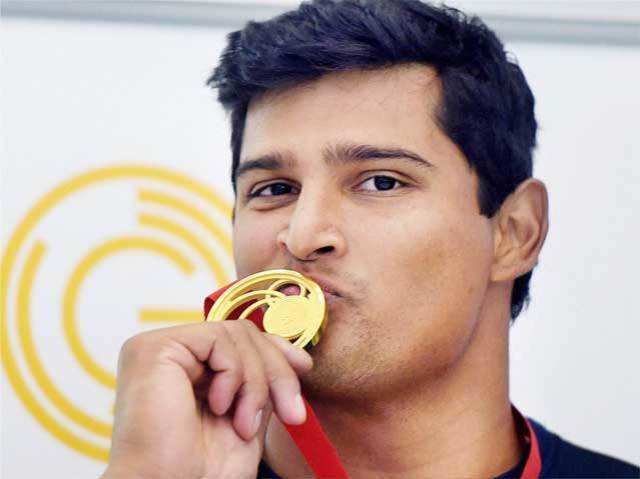 India's Vikas Shive Gowda poses with his gold medal