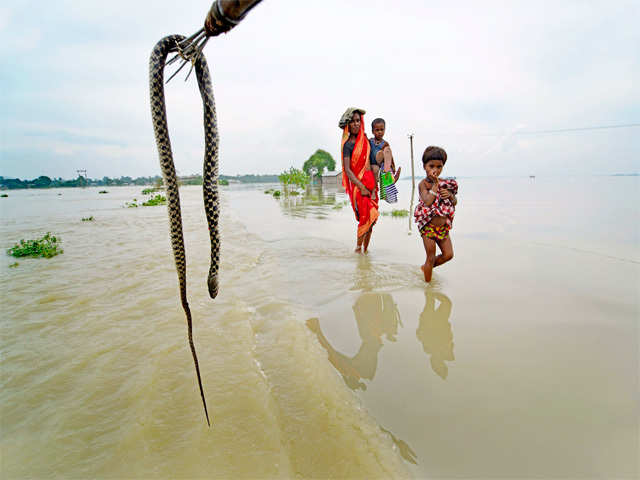 Mother walks her children through floodwaters