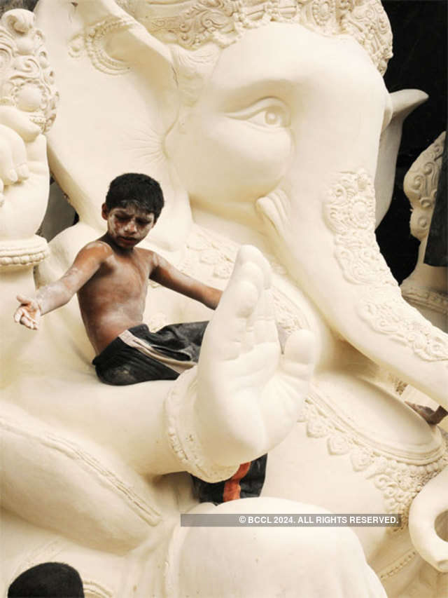 A young boy works on a ganesh idol