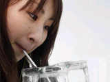 Woman drinks cocktail from an ice glass