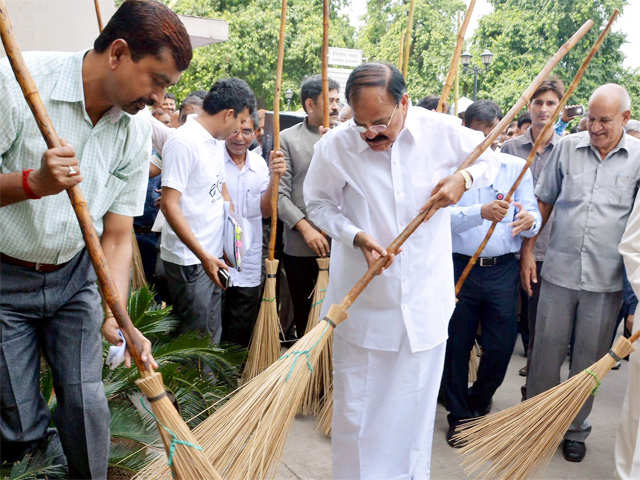 M Venkaiah Naidu weilding the broom