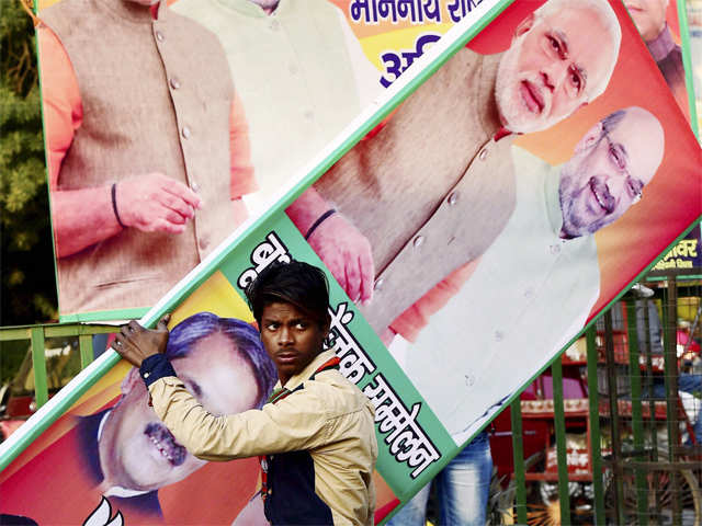 Worker carries an election campaign poster