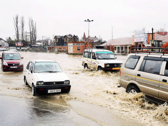 Vehicles wade through a waterlogged road