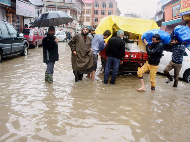 People wade through a waterlogged road