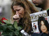 A fan cries as she pays her respects