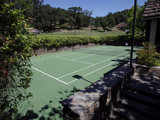 Tennis court behind pool house