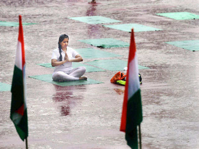 A participant takes part in yoga amidst heavy rain