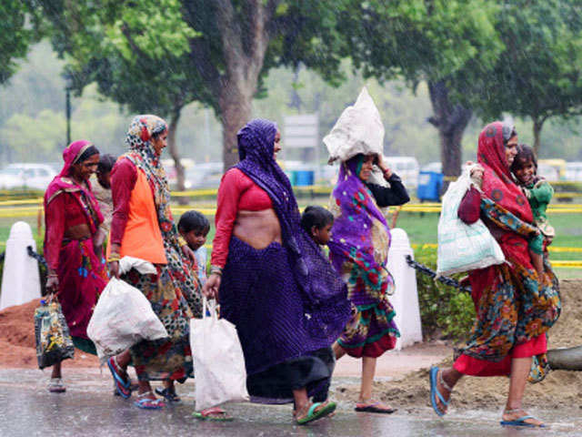 Women labourers walking during monsoon shower