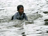 A child plays in a waterlogged lane