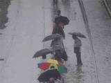 Commuters walk along the flooded track