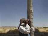 Taliban fighter looks through binoculars