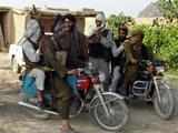 Taliban fighters ride on motor bikes