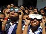 School children use solar viewing googles