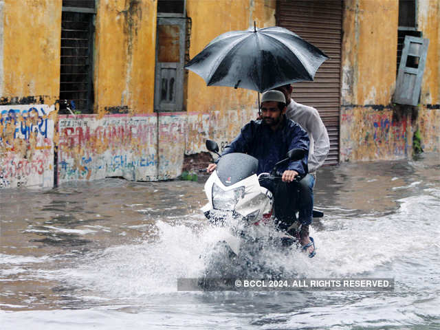 Bikers wade through waterlogged street