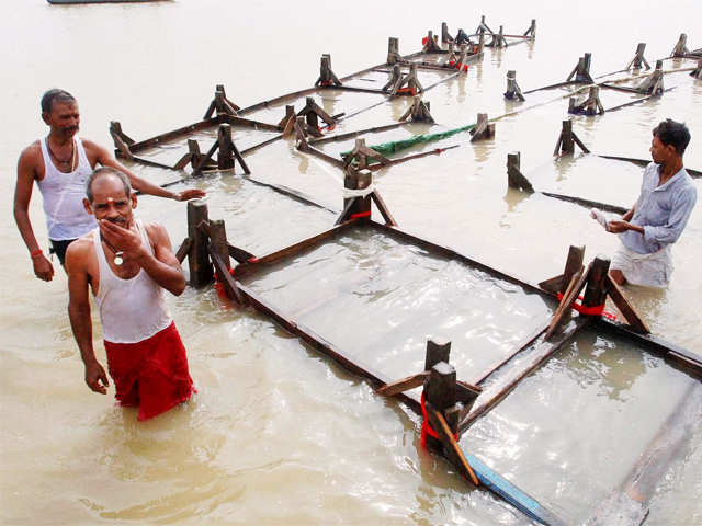 Hindu priests pull a chain of cots