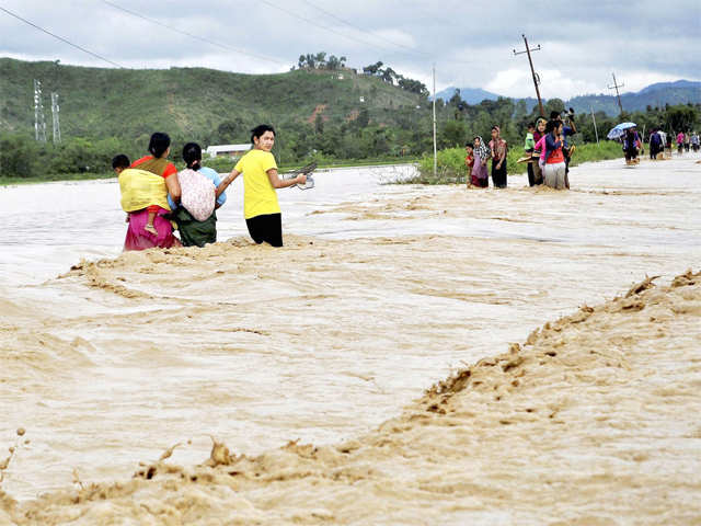 People wades through a flooded road