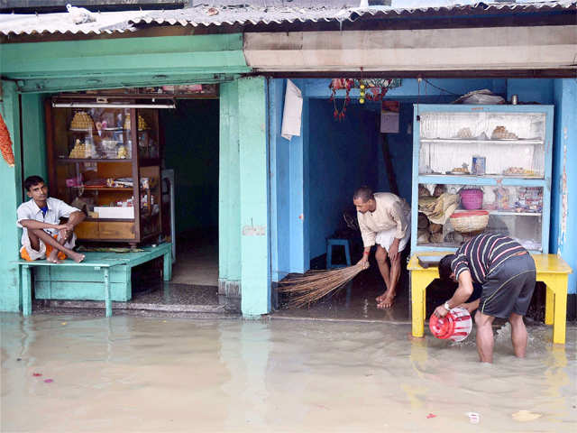 People drain floodwater from their shop