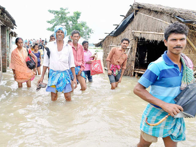 Villagers wading through a flooded road