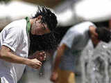 A boy cools off at a public fountain