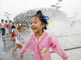 A girl plays in a water fountain