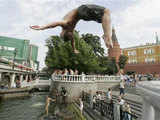 A boy jumps into a fountain