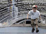 A boy plays under the jets of water