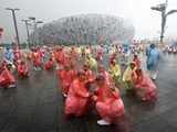 People gesture in the rain