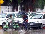 Cyclist with an umbrella in rain