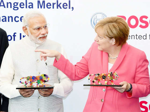 PM Modi & Merkel holding models of Make in India logo