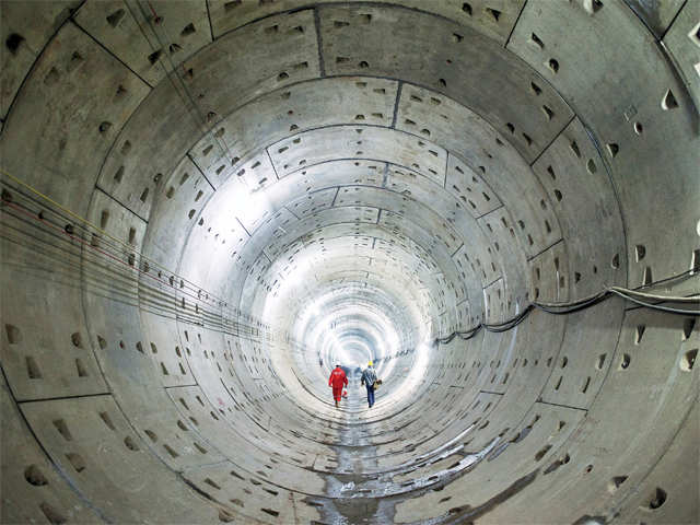 ​Workers walk along a tunnel