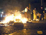 Ultra-Orthodox Jews walk past burning garbage