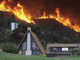 Flames burn behind a home