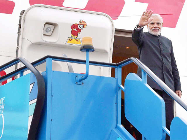 PM Modi waves before his departure for Delhi