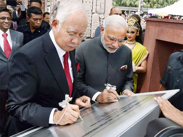 PM Modi and Najib Razak signing a plaque