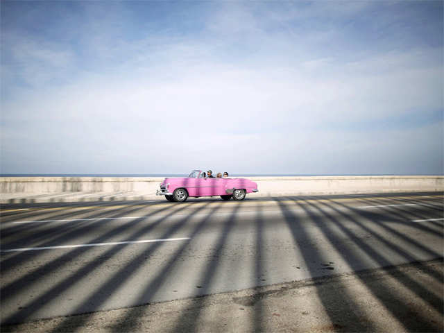 Flagposts cast shadows on vintage car