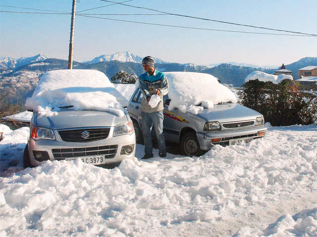 Man clears snow from car