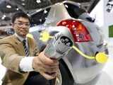 Suzuki worker poses with the charger of Suzuki Swift 