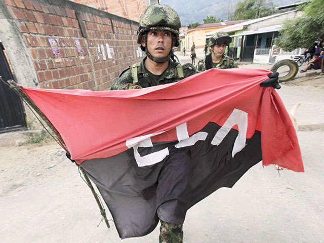 Colombian soldier  with a flag of the National Liberation Army