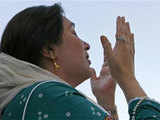 Benazir Bhutto prays as she arrives in Karachi