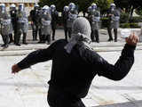 A demonstrator throws a stone