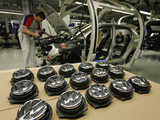 Employees work on the bodywork of Volkswagen Golf car