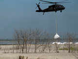 A Louisiana National Guard helicopter airlifts sand bags