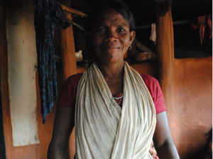 A tribal woman in Kandhamal's Burlubaru village showing millets she has grown in her forest farm
