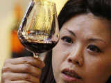 A visitor checks a wine at Vinexpo Asia-Pacific